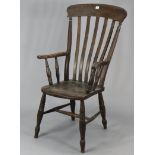 A Windsor lath-back chair with a hard seat, & on turned legs with spindle stretchers.