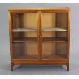 A mahogany 1960’s bookcase with two adjustable shelves enclosed by a pair of glazed doors, & on