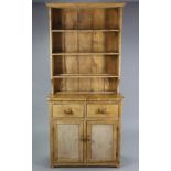 A small pine dresser the upper part fitted three open shelves & with a panelled back, the base