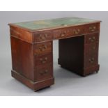 A late 19th/early 20th century mahogany pedestal desk inset gilt-tooled green leather to the