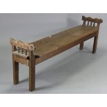 A 19th century French fruitwood bench with raised spindle ends & on short square legs, 70” long.