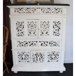 A continental-style white painted carved & pierced wooden upright side cabinet with a polished black