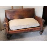 An early/mid 20th century brass studded tan leather two-seater settee with a shaped back & loose