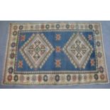 A Turkish rug of blue & ivory ground & with repeating geometric design to centre within a wide flora