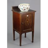 A 19th century inlaid-mahogany bedside cupboard enclosed by a panel door, & on square tapered