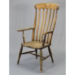 A lath-back elbow chair with a hard seat, & on turned legs with spindle stretchers.