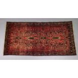 A North West Persian Zanjan rug of madder ground with repeating geometric designs surrounded by a