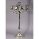 A large silvered-metal table candelabrum with four scroll arms around the central sconce, on