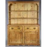 A Victorian pine dresser, with moulded cornice & two open shelves above two deep frieze drawers with