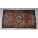 An antique Hamadan rug of madder ground with central lozenge design on a blue field, in multiple