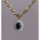 A 9ct gold pendant set oval sapphire within a border of small white stones, on a 9ct gold fancy-link