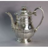 A George III silver coffee pot of semi-fluted baluster form, with gadrooned rim & foliate finial