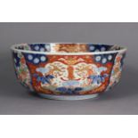 A Japanese porcelain large circular deep bowl with all-over ‘Imari’ decoration, on short foot;