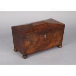 An early 19th century figured mahogany tea caddy of sarcophagus form, the hinged lid revealing two