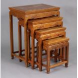 A nest of four Chinese hardwood occasional tables with carved decoration, on slender square legs,