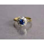 A sapphire & diamond ring, the round-cut sapphire weighing approx. 0.6carat, set within a border