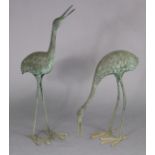 A pair of 20th century metal garden ornaments in the form of standing crane, 35” & 23” high.