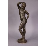 A 20th century bronzed resin sculpture of a standing female nude, on circular plinth base, 23½”