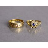 An Edwardian 18ct gold ring set small round-cut sapphire within a border of tiny rose diamonds,