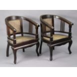 A pair of teak tub-shaped chairs inset woven-cane seats & backs, & on cabriole legs.