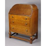 A mid-20th century oak bureau with a rounded top, having a fitted interior enclosed by a fall-