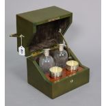 A green leatherette travelling case fitted with a pair of cut-glass decanters, & ten plated