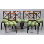 A matching set of six rail-back dining chairs with padded seats.