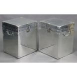 A pair of silvered-metal travelling trunks each with a hinged lift-lid, & with swing side handles,