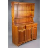 A Ducal pine dresser fitted three frieze drawers above cupboard enclosed by three fielded panel