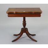 A mahogany serpentine-front tea table with a fold-over top, & on fluted & vase-turned centre