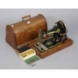 A Singer hand-sewing machine, with an oak case.