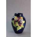 A Moorcroft pottery “Hibiscus” vase of ovoid shape & deep blue ground, 5” high x 3½” wide. Bears