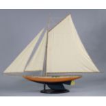A LARGE PAINTED WOODEN POND YACHT, with sails & stand, 60” long x 46¾” high.