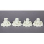 A set of four Crown Staffordshire fine bone china white-glazed candle holders, each on shaped