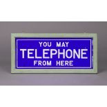 A vintage blue & white glass sign “You May Telephone From Here”, in painted wooden frame, 9” x 18”