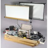 An Aldis film projector; two slide projectors; three projector screens; a movie camera, etc.