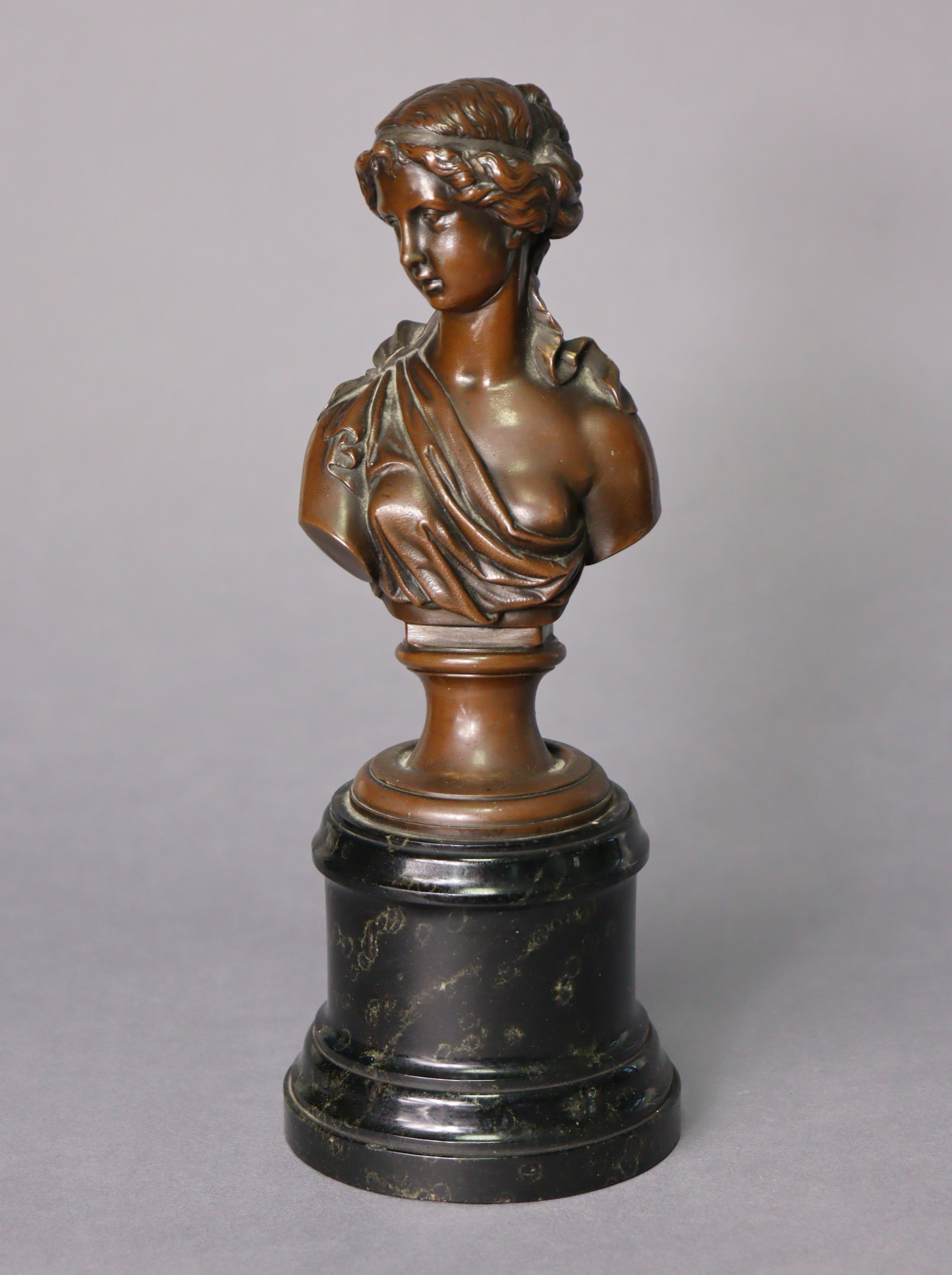 A bronze bust of a lady looking to her right, inscribed “Depon. Gust. Grohe.”, on round socle, 9¼”