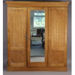 A Victorian ash wardrobe with a moulded cornice, having a fitted interior enclosed by a pair of