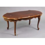 A reproduction mahogany low coffee table with a moulded edge to the shaped top & on four slender