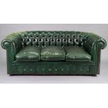 A brass studded buttoned green leather three-seater chesterfield settee with loose cushions to seat,