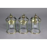 A set of three brass frame cylindrical hall lanterns each inset glass panels, 8” diameter x 14”