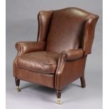 A Laura Ashley tan leather wing-back reclining armchair on short turned legs with brass castors.