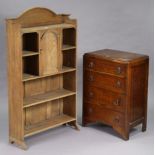 An oak standing bookcase with six open shelves & with cupboard to centre enclosed by a panel door,