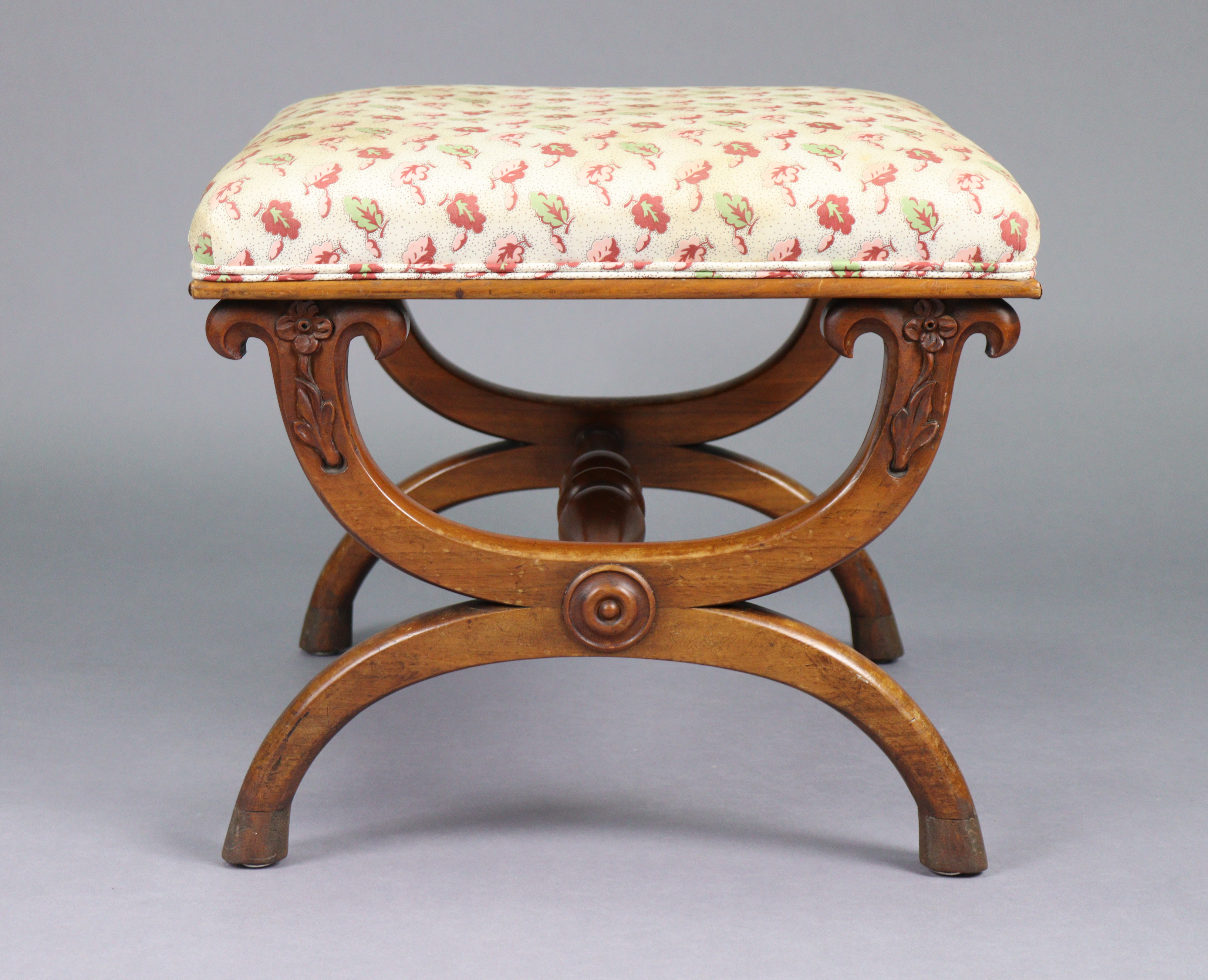 An early 19th century mahogany stool with padded rectangular seat upholstered cream leaf &