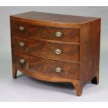 A Georgian mahogany bow-front chest fitted three long drawers with oval brass swing handles, on