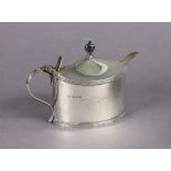 A George V silver mustard pot of plain oval straight-sided form, urn finial to the hinged lid,