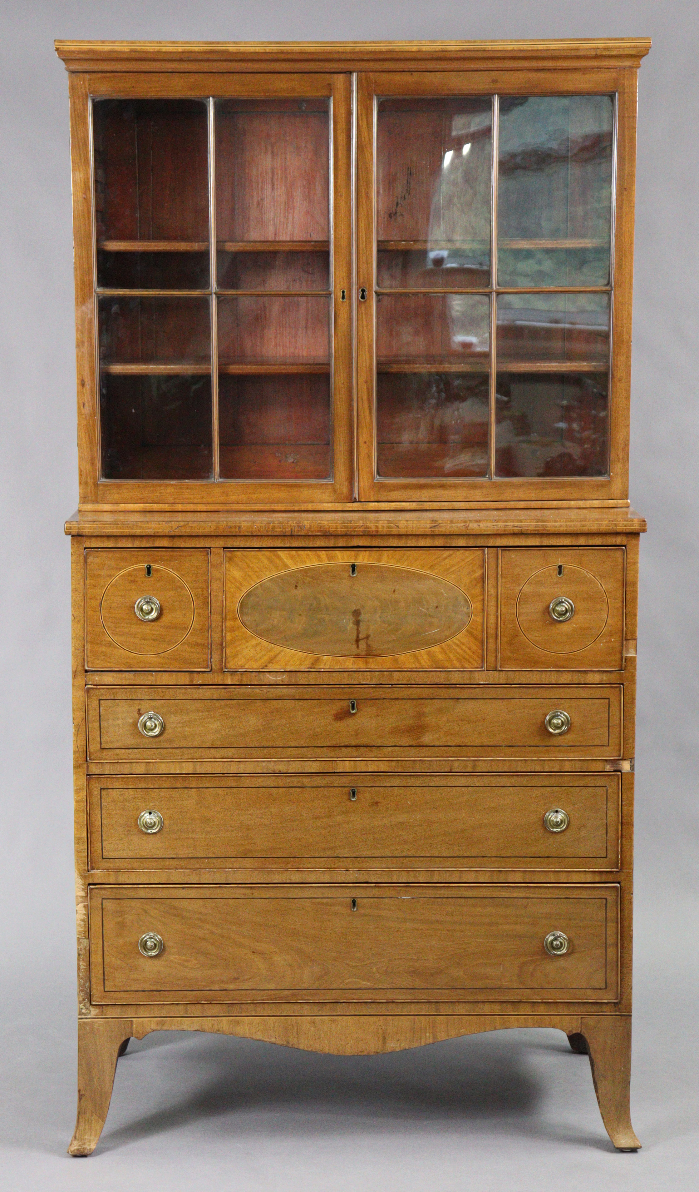 An early 19th century inlaid-mahogany cabinet with moulded cornice above two adjustable shelves