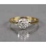 An 18ct. gold & platinum ring set cluster of small diamonds; size: T, weight: 2.8 gm.