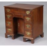 A George III style mahogany small kneehole desk with moulded edge to the rectangular top, fitted