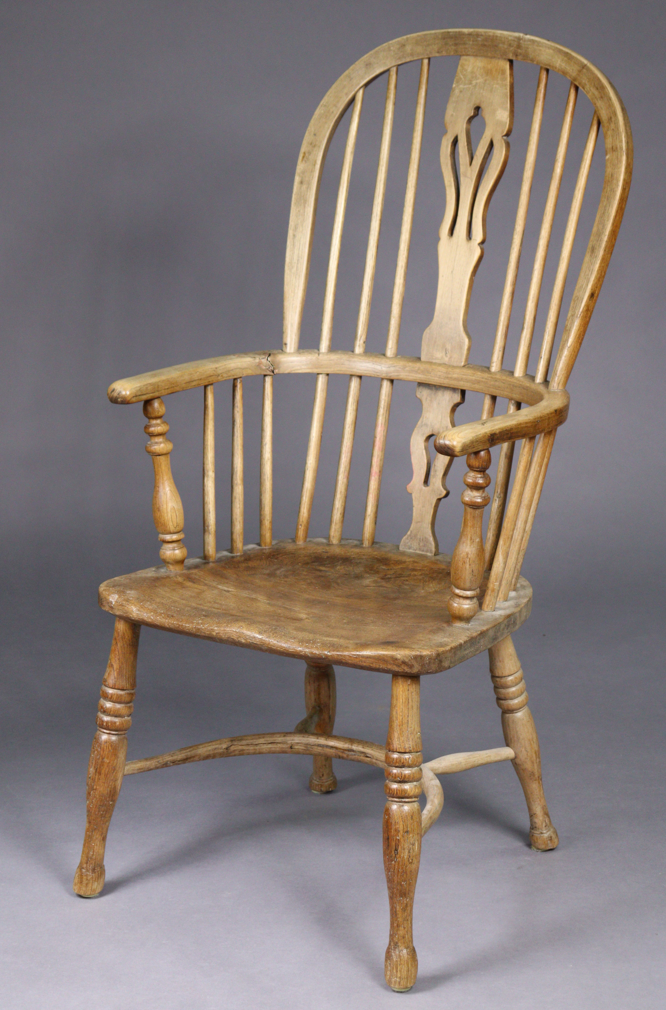 A 19th century ash & elm Windsor elbow chair with pierced & shaped splat to the hooped spindle back,